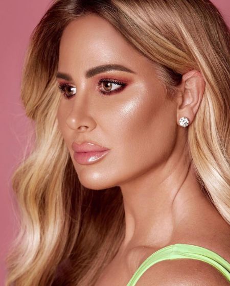 Kim Zolciak in a green top poses for a photoshoot.